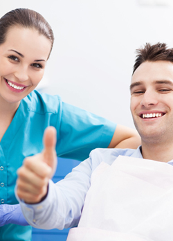 Smiling man in dental chair giving thumbs up