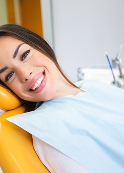 Woman sitting back in dental chair and smiling