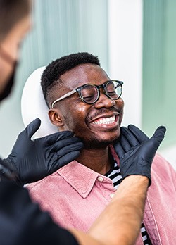 Dentist looking at patient's smile in treatment chair