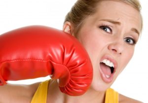 woman punching herself with boxing glove