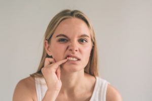 Woman poking at her irritated gums