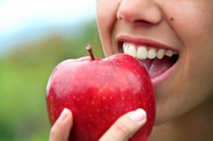 close up person eating an apple 