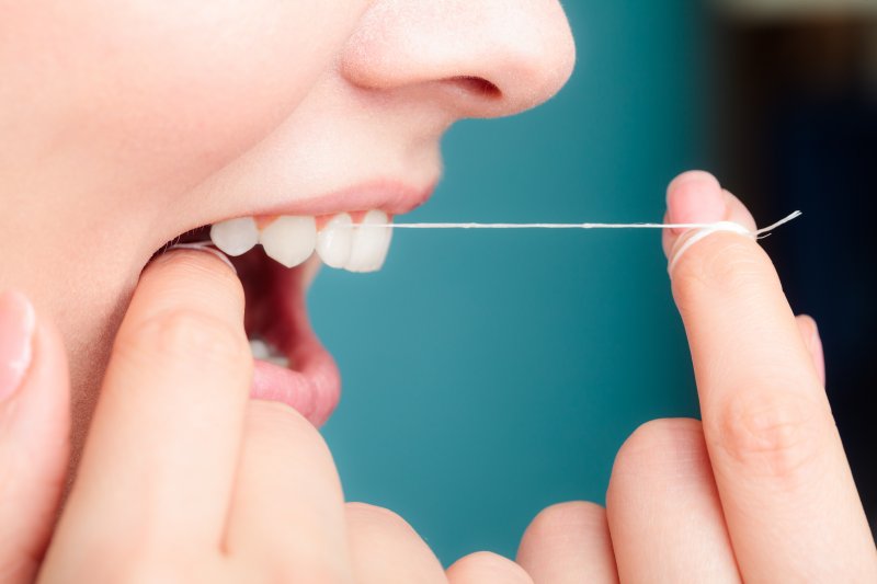 Woman flossing her teeth