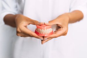 dentist holding dentures