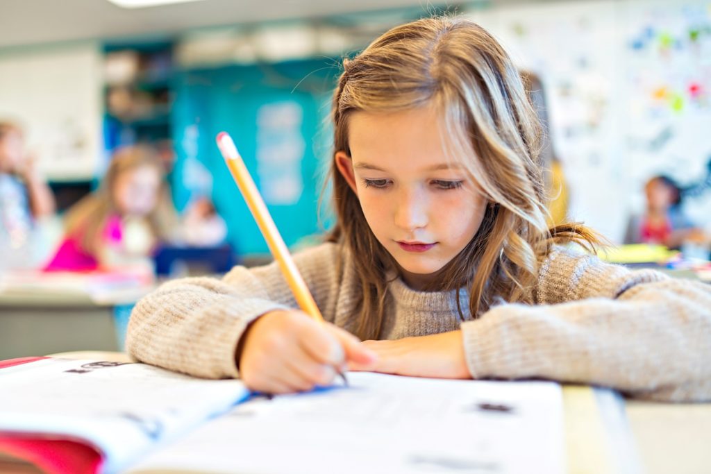 Young girl focusing on class assignment