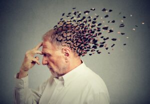 Older man touching his forehead while the back of his head fractures artistically