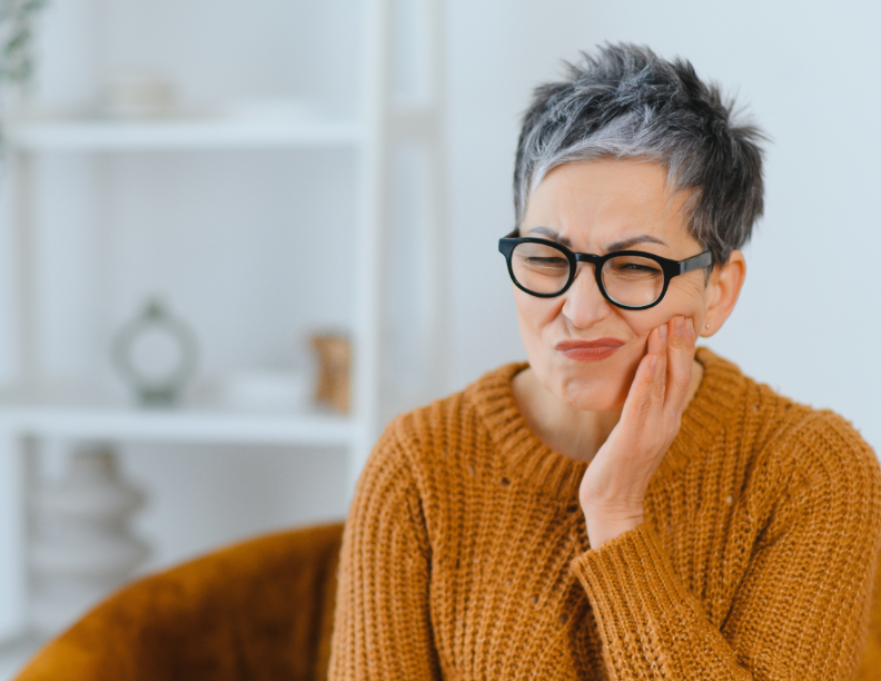 Woman holding jaw in pain